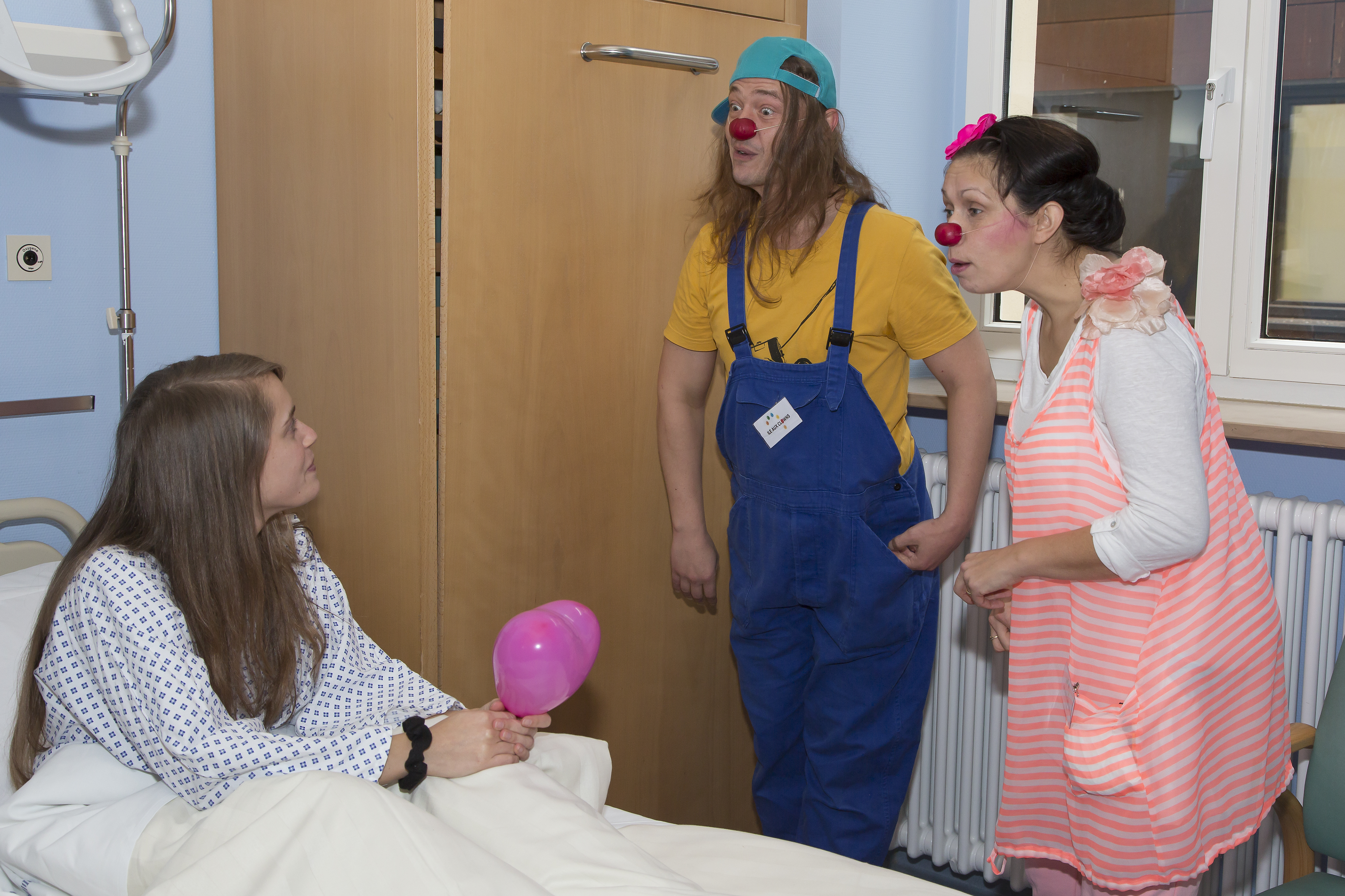 Clowns making a young girl laugh